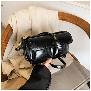 Detail of vintage black oil wax leather bag with gold PARIS metal logo and brass hardware