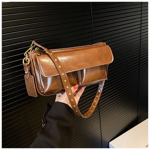 Close-up of retro brown oil wax leather bag with PARIS logo and gold studded strap