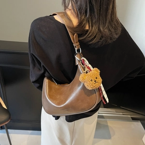 Brown leather crescent shoulder bag for women with plush bear and silk scarf charm