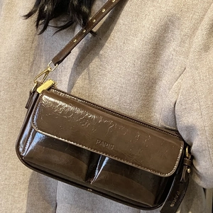 Dark brown patent leather crossbody bag with PARIS embossing and metallic rivet strap