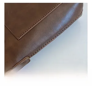Close-up of precise stitching on vintage brown leather handbag with microtexture detail