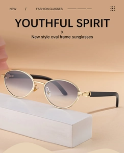 Detailed macro view of oval sunglasses with golden metal frame and gray gradient lenses