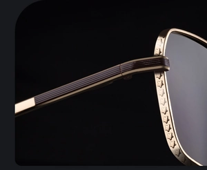 Vue macro de la monture dorée avec gravures d'étoiles et texture marron sur les lunettes