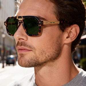Detail of vintage square sunglasses with tortoise frame and gold eagle logo on temple