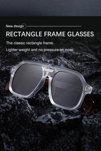 Detail of rectangle frame sunglasses with tortoise temples on dark textured rock