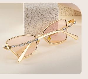 Detail of luxury cat-eye sunglasses with gold metal frame and sparkling crystal rhinestones