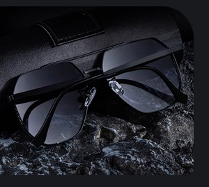 Détails de lunettes aviateur noires avec verres dégradés sur étui en cuir