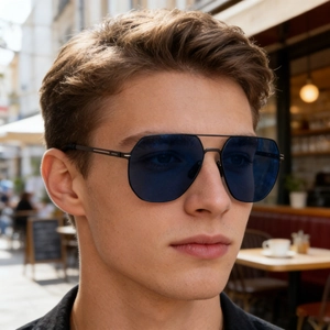 Vue rapprochée de lunettes aviateur avec verres bleus et monture noire portées par le mannequin
