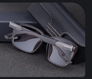 Detail of square matte sunglasses with woven metal hinges and leather storage case