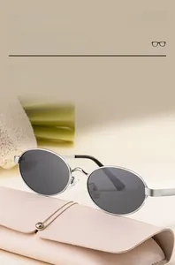 Lunettes de soleil ovales en métal argenté avec verres anti-UV près d'un étui rose