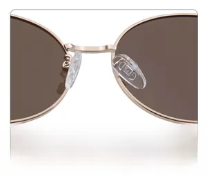 Close-up of soft silicone nose pads and polished gold metal bridge on oval sunglasses