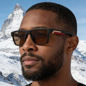 Detail einer eckigen Polarisations-Sonnenbrille mit roter Wabenstruktur am Bügel und Goldakzent