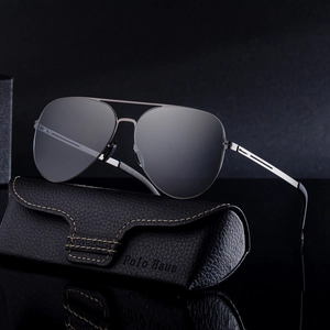 Classic aviator polarized sunglasses with silver metal frame and leather case on dark surface