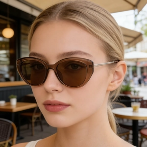 Donna indossa occhiali da sole cat-eye marroni con stanghette in acciaio inox all'aperto