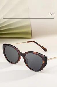 Dettaglio occhiali da sole cat-eye tartarugati con sottili stanghette in oro metallo