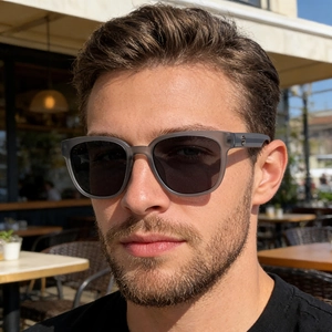 Close-up of polarized sunglasses featuring matte grey frames and round metal logo detail