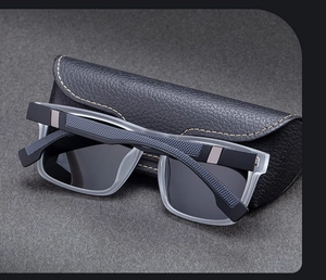 Detail of square polarized sunglasses with frosted frame and leather case with yellow stitching