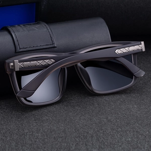 Detail of polarized square sunglasses with silver textured metal hinges and leather case