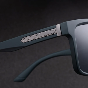 Close-up of matte sunglasses hinges with engraved geometric diamond pattern