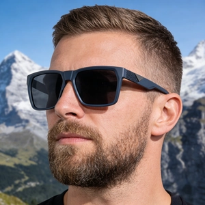 Man wearing square polarized sunglasses with textured temples against snowy mountains