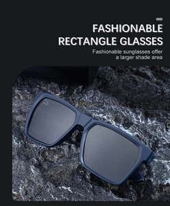 Detail of dark blue rectangular polarized sunglasses on a natural stone textured background