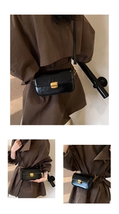Detail of black glossy small square bag with golden turn-lock and chain shoulder strap