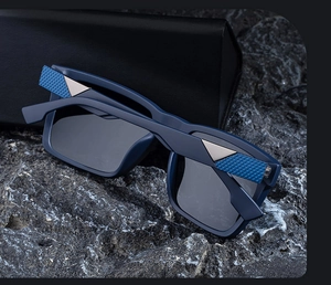 Detail of square polarized sunglasses with silver triangle accent and blue textured temple