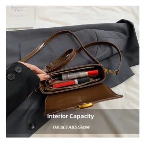 Detail view of the spacious inner compartment and zipper of the dark brown crossbody bag