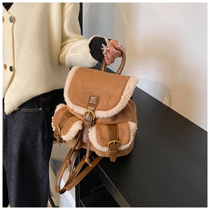 Detail of brown faux suede backpack with sherpa trim and double front buckled pockets