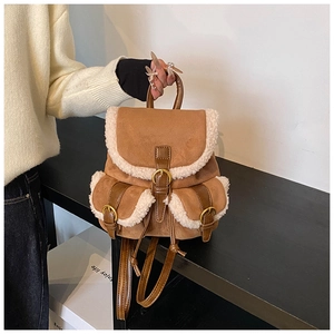 Detail of faux suede backpack with sherpa trim and vintage gold metallic buckles