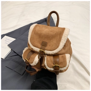 Detail view of vintage brown suede backpack with white faux shearling trim and metal buckle