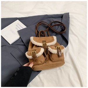 Detail of vintage brown suede backpack with white faux shearling trim and gold buckles