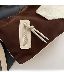 Detailed view of suede tote with contrast stitching, plush faux fur, and leather zipper pull