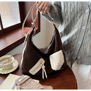 Detail of hobo bag with contrast stitching and fuzzy pocket in a cozy winter setting