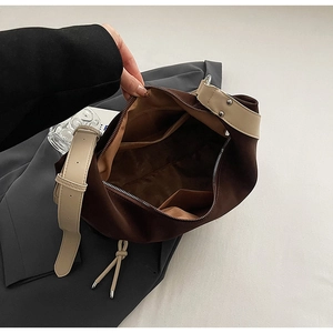 Detail view of large capacity bag interior with zipper pocket and white leather strap