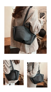 Detail of black pebbled leather tote bag with white contrast stitching and rivets