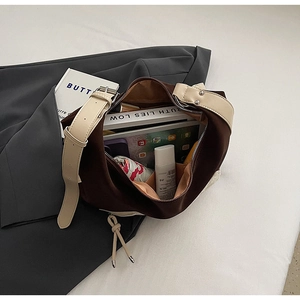 Detail shot of large contrast tote bag showing storage capacity for tablets and daily items