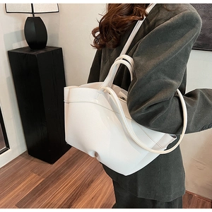 Minimalist white litchi pattern tote bag with shoulder strap shown on a model