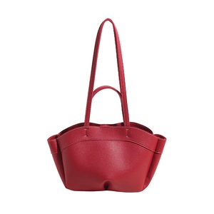 Detail view of red tote bag featuring premium lychee texture and white contrast stitching