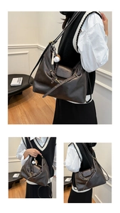 Detail of dark brown leather tote showing flap closure, buckle and baseball charm