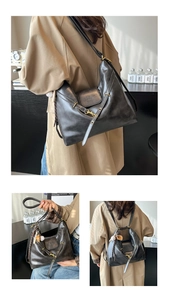 Detail of black vintage tote bag showing metal hardware and baseball charm in lifestyle setting