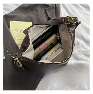 Detailed interior of a large brown tote showing the spacious lining and vintage brass hardware