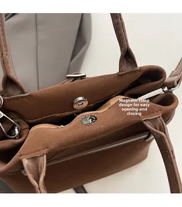 Detail of suede tote bag featuring a convenient magnetic closure and inner zipper pocket
