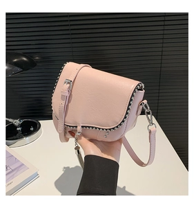 Détails du sac de selle rose clair avec des rivets argentés et des pompons en métal