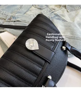 Detail of black lychee grain leather handbag with stylish silver teardrop metal clasp