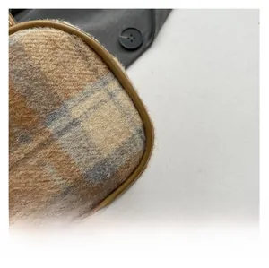 Close-up of classic check plaid woolen fabric with premium brown leather piping detail