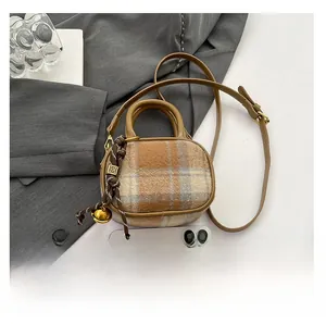 Mini brown plaid bowling bag with leather handles and smartphone for size comparison