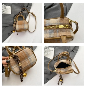 Detail view of plaid mini bowling bag featuring leather handles and woven charm detail