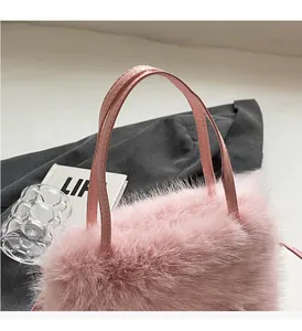 Détail du sac bandoulière en peluche rose avec fourrure douce et poignées en cuir