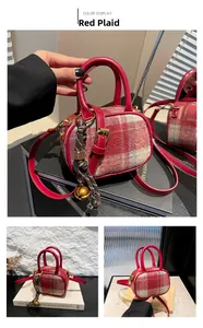 Detail of red plaid tweed mini bowling bag with leather handles and gold bell charm